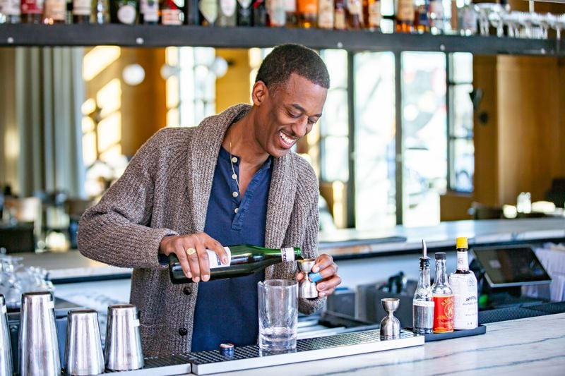 Navarro Carr, bar manager at Southern National, builds a Bitter Heart cocktail featuring gin, cynar and amaretto. (Ryan Fleisher for The Atlanta Journal-Constitution)  