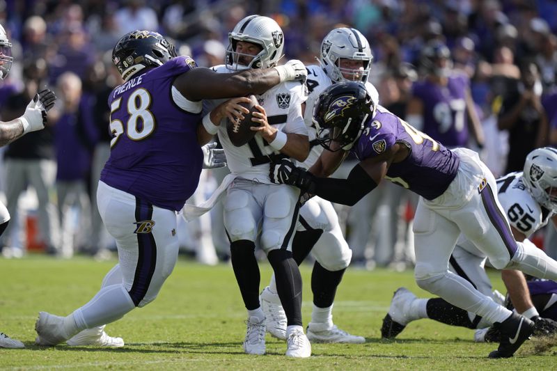 Baltimore Ravens defensive tackle Michael Pierce (58) and linebacker Odafe Oweh (99) sack Las Vegas Raiders quarterback Gardner Minshew (15) during the second half of an NFL football game, Sunday, Sept. 15, 2024, in Baltimore. (AP Photo/Stephanie Scarbrough)