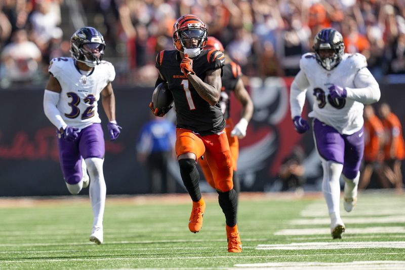 Cincinnati Bengals wide receiver Ja'Marr Chase (1) runs in front of Baltimore Ravens safety Marcus Williams (32) and running back Owen Wright (36) for a long touchdown after making a catch during the second half of an NFL football game, Sunday, Oct. 6, 2024, in Cincinnati. (AP Photo/Carolyn Kaster)