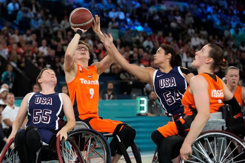 Netherlands' Bo Kramer shoots as Ixhelt Gonzalez from the U.S. defends during the gold medal match of the women's wheelchair basketball between Netherlands and United States, at the 2024 Paralympics, Sunday, Sept. 8, 2024, in Paris, France. (AP Photo/Christophe Ena)