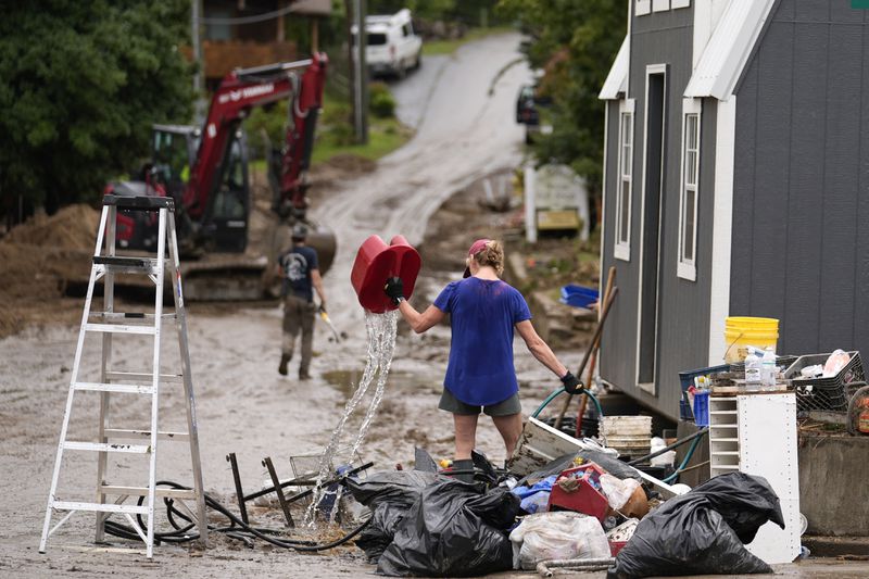 FILE - People clean up in the aftermath of Hurricane Helen, Oct. 1, 2024, in Hot Springs, N.C. (AP Photo/Jeff Roberson, File)