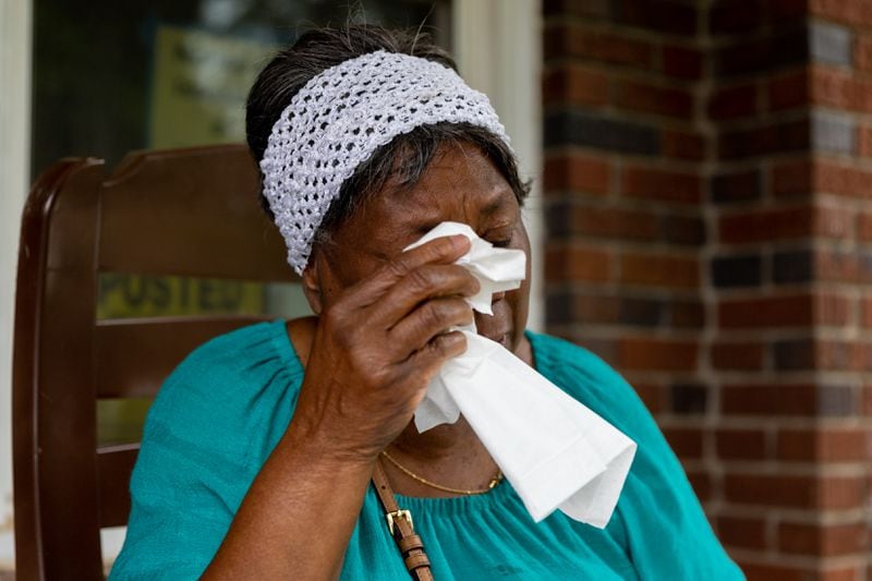Dorothy Williams becomes emotional in front of her home while speaking about a home repair scam she fell victim to in Atlanta on Monday, May 13, 2024. (Arvin Temkar / AJC)