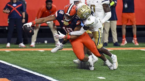 Syracuse tight end Oronde Gadsden II (19) reaches out for the goal to score a touchdown despite the defensive effort of Georgia Tech defensive back Warren Burrell (4) during the second half of an NCAA football game on Saturday, Sept. 7, 2024 in Syracuse, N.Y. Syracuse won 31-28. (AP Photo/Hans Pennink)