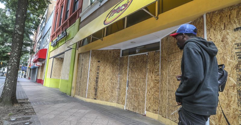 Businesses in Atlanta along Peachtree Street across from Woodruff Park were boarded up on Monday, June 1, 2020, after losing glass to vandals. Over the weekend vandals left a trail of smashed windows and graffiti in their wake as protests against police brutality continued across the country. JOHN SPINK/JSPINK@AJC.COM