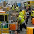 FILE - Amazon employees load packages on carts before being put on to trucks for distribution to customers for Amazon's annual Prime Day event at an Amazon's DAX7 delivery station on July 16, 2024, in South Gate, Calif. (AP Photo/Richard Vogel, File)