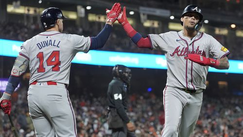 Orlando Arcia is congratulated by Adam Duvall (14) after scoring against the San Francisco Giants during the 10th inning of a baseball game in San Francisco, Monday, Aug. 12, 2024. (AP Photo/Jeff Chiu)