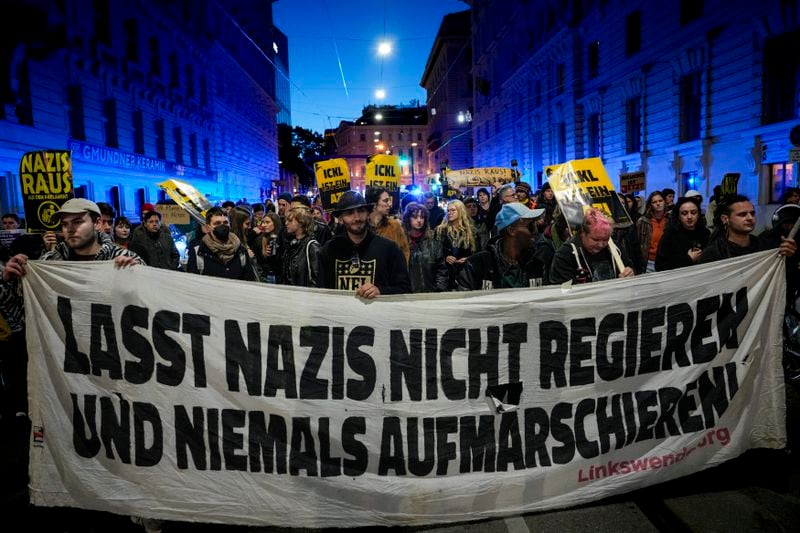 Anti right wing protesters shout slogans holding a banner that reads "Don't let Nazis rule and never let them march" near the parliament building, in Vienna, Austria, Sunday, Sept. 29, 2024, after polls closed in the country's national election. (AP Photo/Andreea Alexandru)