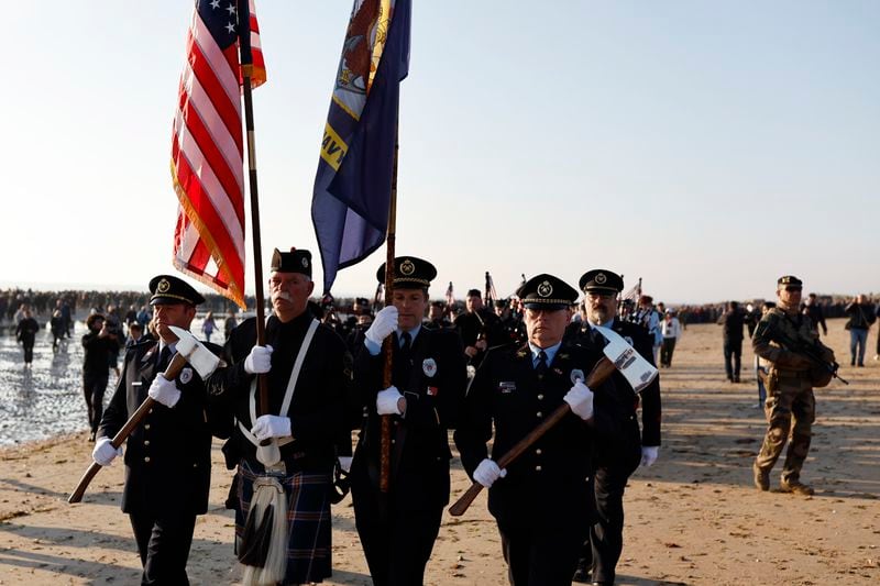 Participants march in a ceremony today at Utah Beach in France.