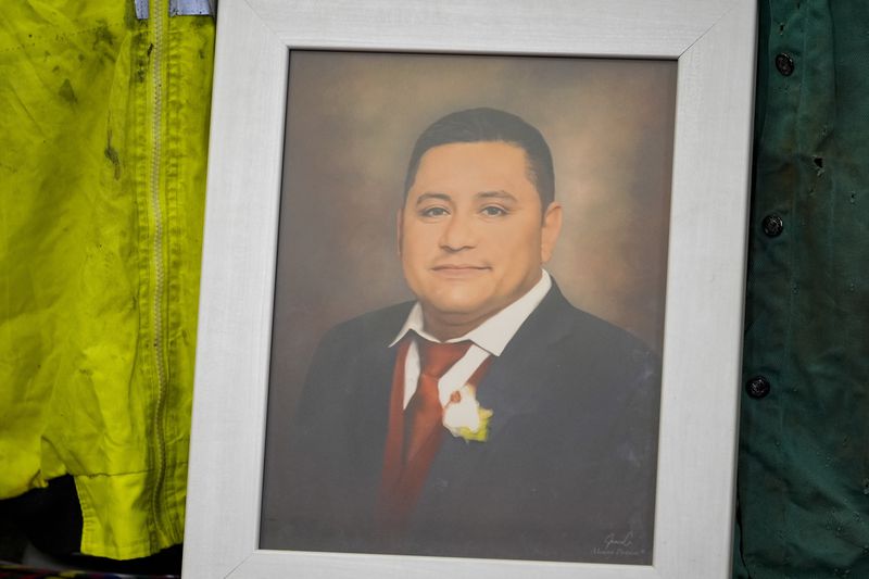 A portrait of Miguel Luna, a worker who died during the collapse of Baltimore's Francis Scott Key Bridge, is displayed among articles of his welding gear, Tuesday, Sept. 17, 2024, during a press conference in Baltimore. (AP Photo/Stephanie Scarbrough)