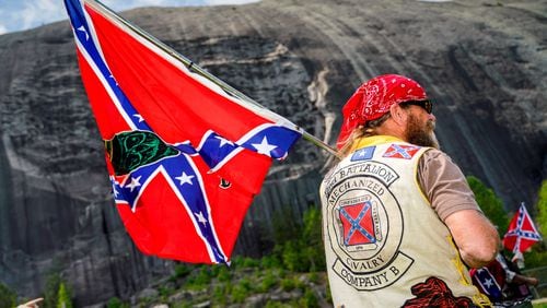 A man flies a Confederate flag at the base of Stone Mountain on Saturday morning, April 30, 2022, as the Sons of Confederate Veterans gathered at Stone Mountain Park. (Photo: Ben Hendren for The Atlanta Journal Constitution)