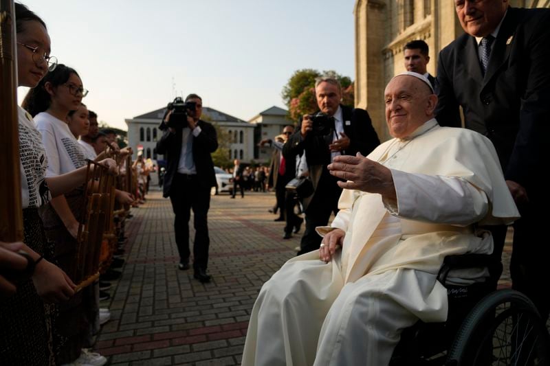 Pope Francis is greeted by faithful as he arrives at the Cathedral of Our Lady of the Assumption in Jakarta, Wednesday, Sept. 4, 2024. Pope Francis urged Indonesia to live up to its promise of "harmony in diversity" and fight religious intolerance on Wednesday, as he set a rigorous pace for an 11-day, four-nation trip through tropical Southeast Asia and Oceania that will test his stamina and health. (AP Photo/Gregorio Borgia)