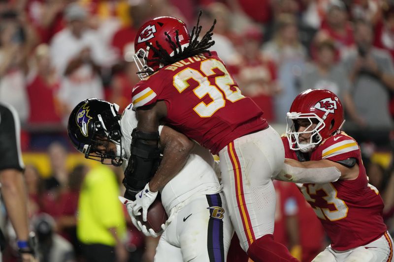 Baltimore Ravens tight end Isaiah Likely, left, catches a pass out of bounds as Kansas City Chiefs linebacker Nick Bolton (32) and linebacker Drue Tranquill (23) defend as time time expires in the second half of an NFL football game Thursday, Sept. 5, 2024, in Kansas City, Mo. The Chiefs won 27-20. (AP Photo/Charlie Riedel)