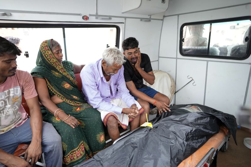 Family members of 37-year-old Ruby, victim of a stampede, mourn after receiving her body from a mortuary as they prepare to leave for their hometown, outside Hathras district hospital, Uttar Pradesh, India, Wednesday, July 3, 2024. Thousands of people at a religious gathering rushed to leave a makeshift tent, setting off a stampede Tuesday that killed more than hundred people and injured scores. (AP Photo/Rajesh Kumar Singh)