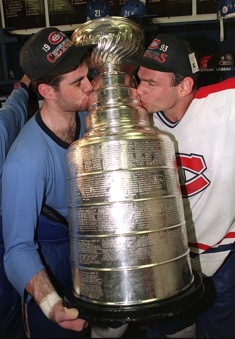 FILE - Montreal Canadiens Ed Ronan, left, and Brian Bellows plant a kiss on the Stanley Cup after defeating the Los Angeles Kings to win the Stanley Cup final, June 9, 1993, in Montreal. It has been 31 years since an NHL team based in Canada won the Stanley Cup — a drought the Edmonton Oilers can end by winning Game 7 at the Florida Panthers on Monday, June 24, 2024. (Ryan Remiorz/The Canadian Press via AP, File)