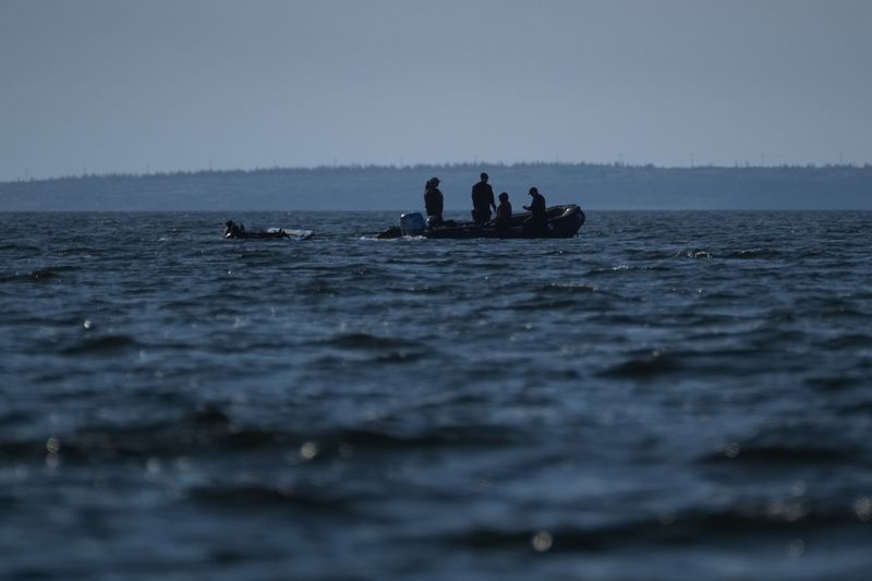 A tour group moves through the Churchill River next to a pod of beluga whales, Sunday, Aug. 4, 2024, near Churchill, Manitoba. (AP Photo/Joshua A. Bickel)