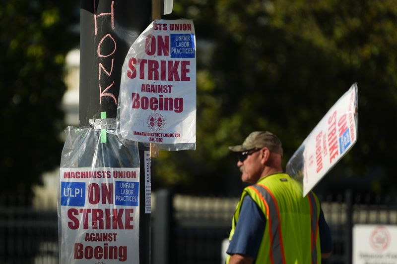 Signs are taped to a light pole as Boeing workers strike Tuesday, Sept. 24, 2024, outside the company's factory in Renton, Wash. (AP Photo/Lindsey Wasson)