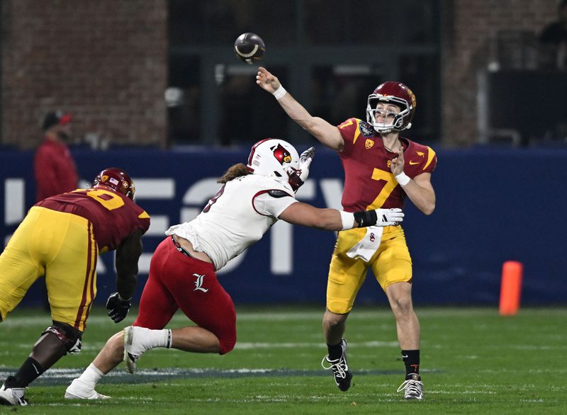 FILE - Southern California quarterback Miller Moss (7) throws a pass under pressure from Louisville defensive lineman Ashton Gillotte (9) during the second half of the Holiday Bowl NCAA college football game, Dec. 27, 2023, in San Diego. (AP Photo/Denis Poroy, File)