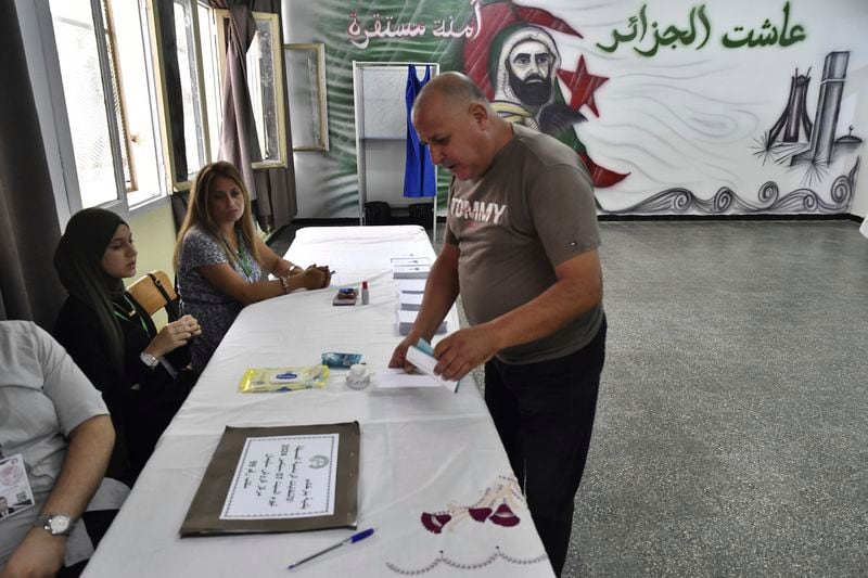 A voter prepares to cast his ballot inside a polling station during the presidential election, Saturday, Sept. 7, 2024, in Algiers, Algeria. (AP Photo/Fateh Guidoum)