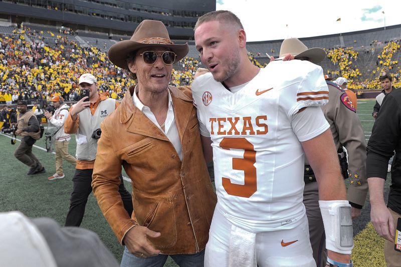 Actor Matthew McConaughey, left, celebrates with Texas quarterback Quinn Ewers (3) after an NCAA college football game against Michigan in Ann Arbor, Mich., Saturday, Sept. 7, 2024. (AP Photo/Paul Sancya)