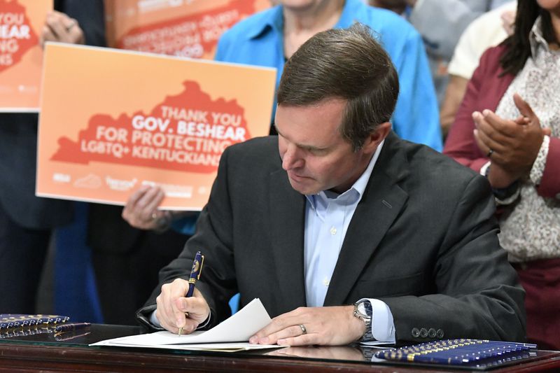 Kentucky Gov. Andy Beshear signs an executive order banning the use of “conversion therapy” on minors, Wednesday, Sept. 18, 2024, in Frankfort, Ky. (AP Photo/Timothy D. Easley)