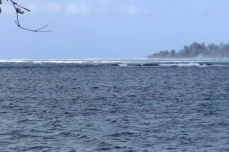 Smoke rises from the sinking HMNZS Manawanui in Upolu, Samoa, Sunday, Sept. 6, 2022. (Dave Poole via AP)