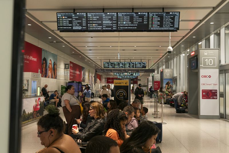 People wait inside at the Union Station bus terminal as a national rail shutdown causes delays in Toronto, Thursday, Aug. 22, 2024. (Paige Taylor White /The Canadian Press via AP)