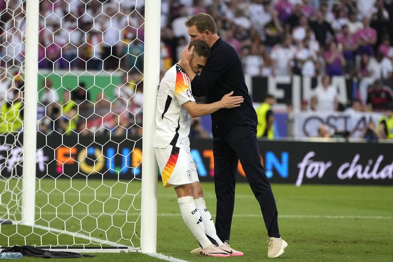 Germany's Joshua Kimmich is hugged by Germany's head coach Julian Nagelsmann at the end of a quarter final match between Germany and Spain at the Euro 2024 soccer tournament in Stuttgart, Germany, Friday, July 5, 2024. (AP Photo/Matthias Schrader)