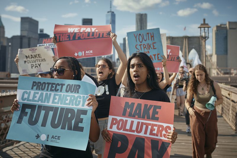 Protesters shout slogans as they cross the Brooklyn Bridge during a Youth Climate Strike march to demand an end to the era of fossil fuels, Friday, Sept. 20, 2024, in New York. (AP Photo/Andres Kudacki)