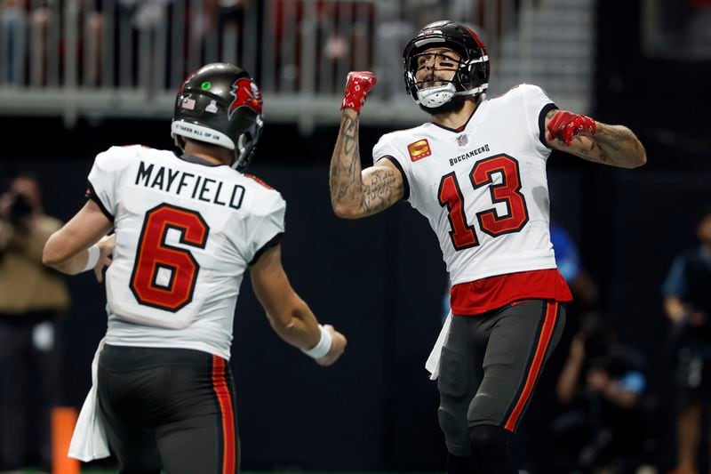 Tampa Bay Buccaneers wide receiver Mike Evans (13) celebrates with quarterback Baker Mayfield (6) after scoring against the Atlanta Falcons during the first half of an NFL football game Thursday, Oct. 3, 2024, in Atlanta. (AP Photo/Butch Dill)