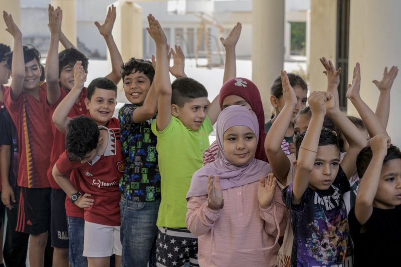 Volunteers of the Russian Cultural Center entertain displaced children at a school in Beirut, Lebanon, Thursday, Oct. 3, 2024, after fleeing the Israeli airstrikes in the south. (AP Photo/Bilal Hussein)