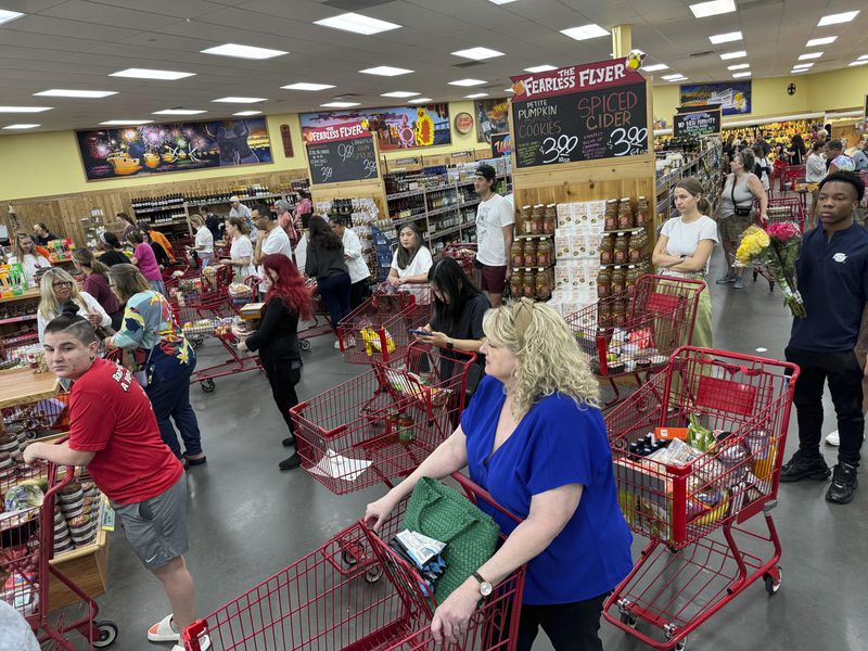 Shoppers in a suburb of New Orleans gather food supplies at a grocery store, Monday, Sept. 9, 2024. (AP Photo/Jack Brook)