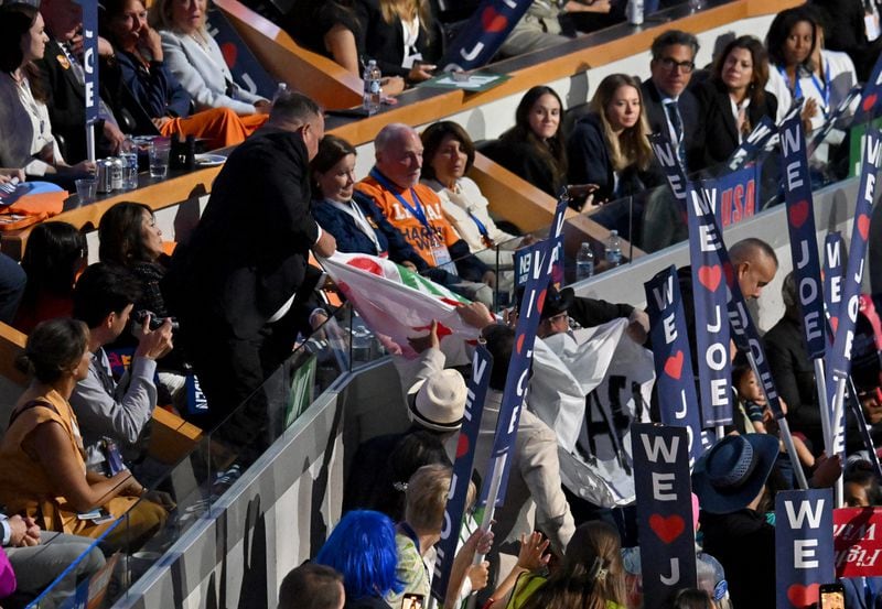 Protesters hold a sign saying "Stop Arming Israel" during President Joe Biden's speech Monday on the first day of the Democratic National Convention in Chicago. (Hyosub Shin / AJC)