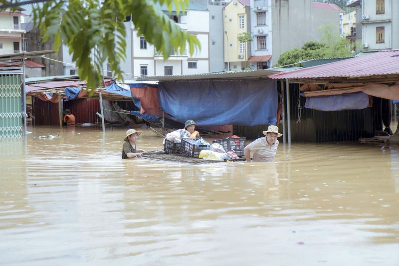 People carry belongings in flood triggered by Typhoon Yagi in Lang Son province, Vietnam Monday, Sept. 9, 2024. (Nguyen Anh Tuan/VNA via AP)