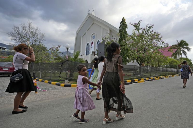 Parishioners arrive to attend a mass at the Immaculate Conception Cathedral in Dili, East Timor, Sunday, Aug. 11, 2024. (AP Photo/Achmad Ibrahim)