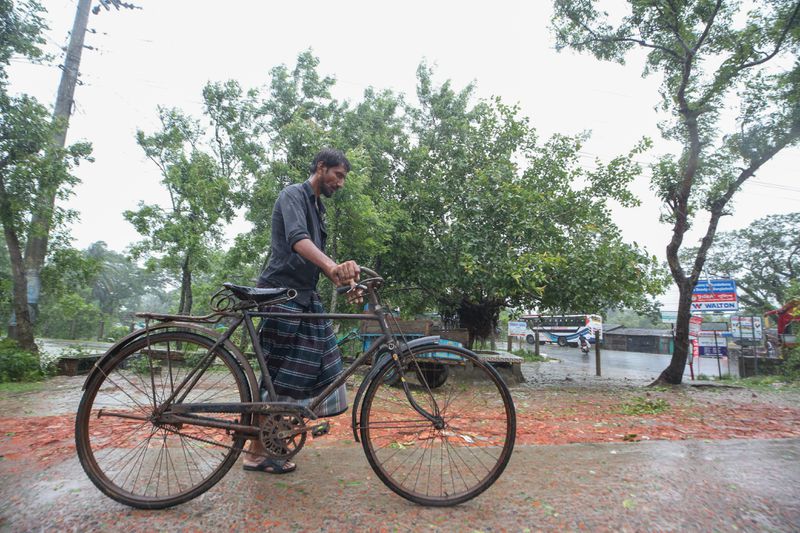 A Bangladeshi man pushes his bicycle during a rain after Cyclone Remal lashed Bangladesh’s southern coast in Shyamnagar, Satkhira District, Bangladesh, Monday, May 27, 2024. (AP Photo/Abdul Goni)
