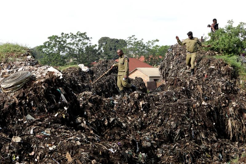 Police officers inspect the site of a collapsed landfill in Kampala, Uganda, Sunday, Aug. 11, 2024. (AP Photo/Hajarah Nalwadda)