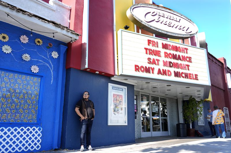 Cinephile Miles Villalon, left, stands underneath the marquee of the New Beverly Cinema revival theater, Friday, Aug. 9, 2024, in Los Angeles. (AP Photo/Chris Pizzello)