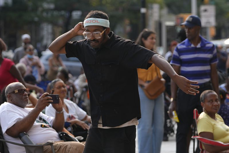 A man dances as JSWISS performs in the Harlem neighborhood of New York, Thursday, Aug. 15, 2024. (AP Photo/Pamela Smith)