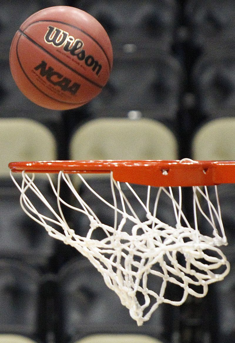 FILE - A basketball with an NCAA logo is shot at the basket during Gonzaga's basketball practice in Pittsburgh, March 14, 2012. (AP Photo/Keith Srakocic, file)