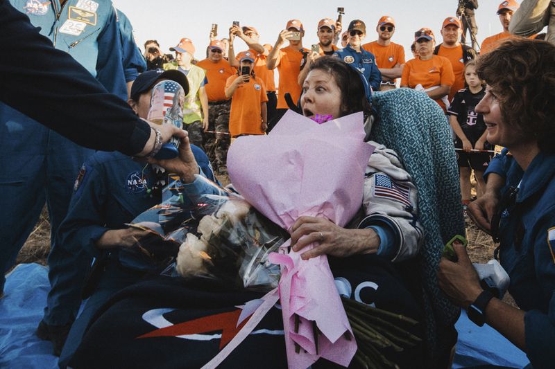 In this photo released by Roscosmos space corporation, NASA astronaut Tracy Dyson is gifted with flowers and a Russian traditional Matryoshka wooden doll depicting her shortly after the landing of the Russian Soyuz MS-25 space capsule carrying NASA astronaut Tracy Dyson, Roscosmos cosmonauts Oleg Kononenko and Nikolai Chub, south-east of the Kazakh town of Zhezkazgan, Kazakhstan, Monday, Sept. 23, 2024. (Ivan Timoshenko, Roscosmos space corporation via AP)