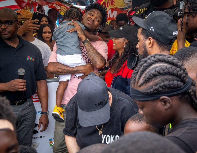 People surround 21 Savage at the fourth annual Issa Back 2 School Drive on Sunday. STEVE SCHAEFER / SPECIAL TO THE AJC