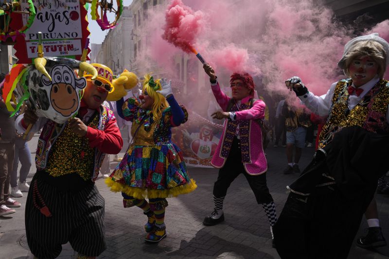 Clowns march celebrating The Day of the Peruvian Clown, in downtown Lima, Peru, Saturday, May 25, 2024. Professional clowns gather annually on this date to honor the beloved clown "Tony Perejil" who died on May 25, 1987 and was known as "the clown of the poor" because he performed in low-income neighborhoods to which he would donate a portion of his earnings. (AP Photo/Martin Mejia)