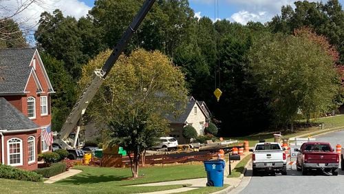 Suwanee is performing emergency repairs to pipe on Ruby Forest Parkway that has failed causing a sinkhole that is threatening an adjacent home. (Karen Huppertz for the AJC)