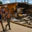 Residents walk past a house damaged by Hurricane John in Coyuca de Benitez, Guerrero state, Mexico, Monday, Sept. 30, 2024. (AP Photo/Felix Marquez)