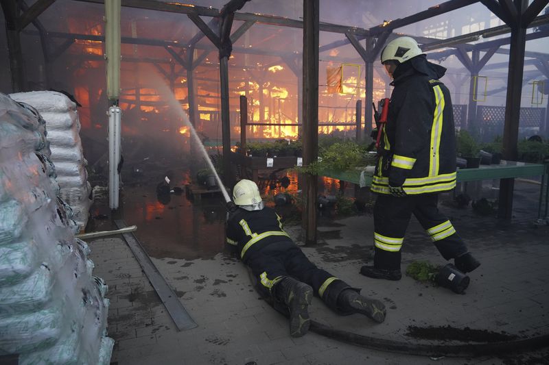 Firefighters put out a fire after two guided bombs hit a large construction supplies store in Kharkiv, Ukraine, Saturday, May 25, 2024. (AP Photo/Andrii Marienko)