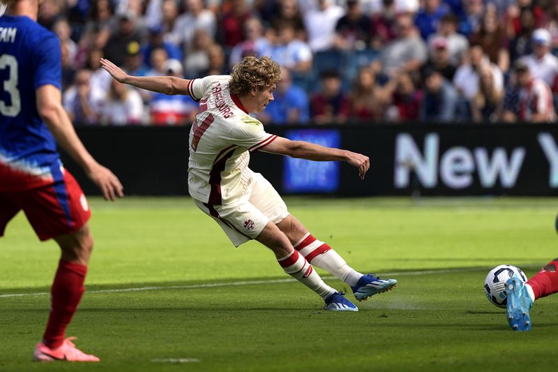 Canada forward Jacob Shaffelburg kicks to score a goal during the first half of an international friendly soccer game against Canada, Saturday, Sept. 7, 2024, in Kansas City, Mo. (AP Photo/Charlie Riedel)