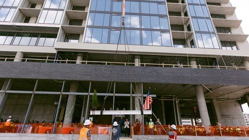 Crews lift a beam during the "topping out" ceremony for a 19-story apartment tower now called The Mitchell within the Centennial Yards development in downtown Atlanta. The ceremony on Thursday, Aug. 22, marked the tower reaching its highest point.