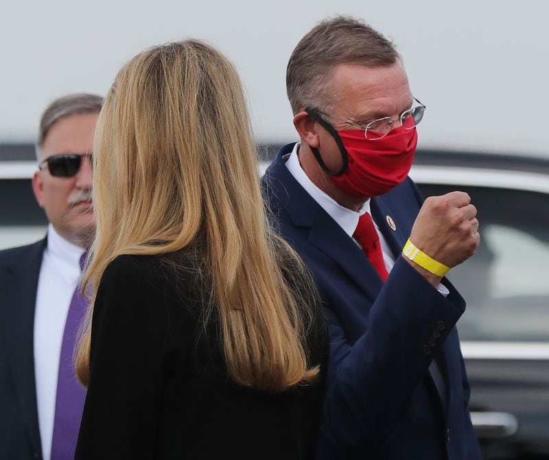 U.S. Sen. Kelly Loeffler passes by her top Republican rival in November's special election, U.S. Rep. Doug Collins, upon the arrival of President Donald Trump in July at at Hartsfield-Jackson International Airport.  Curtis Compton ccompton@ajc.com