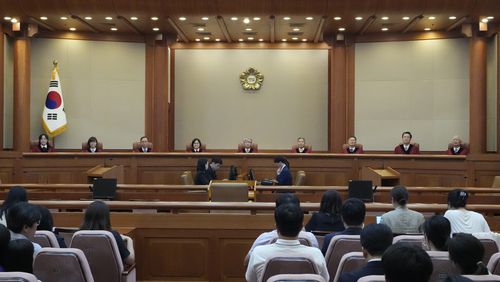 South Korea's Constitutional Court Chief Justice Lee Jong-seok, center, and other judges sit upon their arrival at the Constitutional Court in Seoul, South Korea, Thursday, Aug. 29, 2024. (AP Photo/Lee Jin-man)