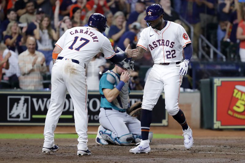 Houston Astros' Victor Caratini (17) and Jason Heyward (22) celebrate in front of Seattle Mariners catcher Cal Raleigh, center, after they both scored on the two-run home run by Heyward during the fifth inning of a baseball game Tuesday, Sept. 24, 2024, in Houston. (AP Photo/Michael Wyke)